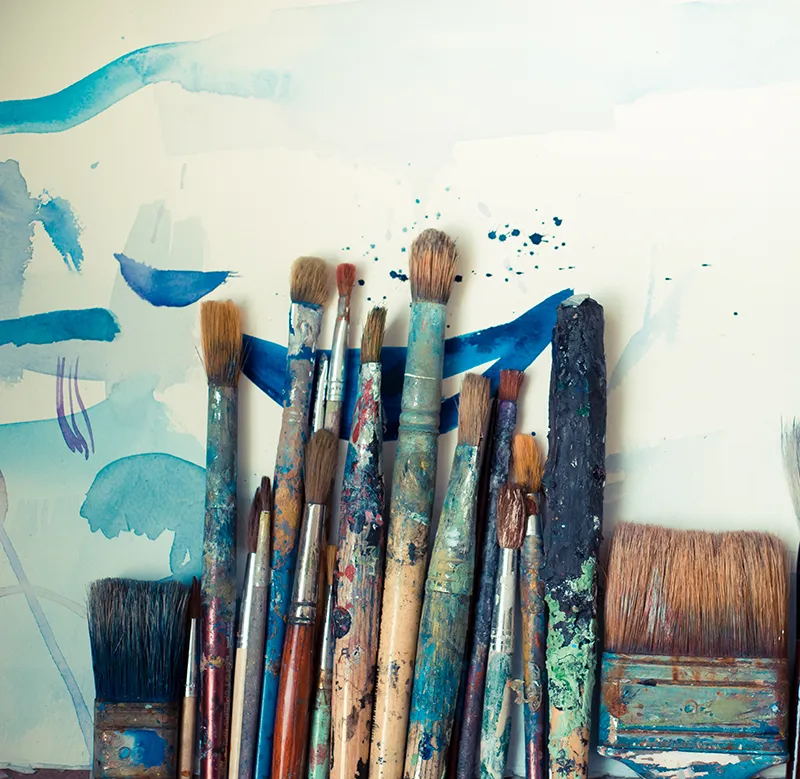 Paint brushes laying on a canvas.